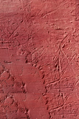 Red-brown textured background. Cement surface with cracks and scratches painted with red paint. Close-up, top view, vertical, plenty of free space for text.