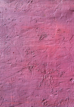 Bright fuchsia textured background. Cement surface with cracks and scratches painted with pink paint. Close-up, top view, vertical, plenty of free space for text.