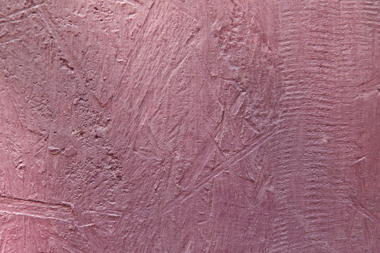 Powdery pink background. Cement surface with cracks and scratches painted with pink paint. Close-up, top view, horizontal, plenty of free space for text.