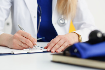 Female doctor hand hold silver pen filling patient