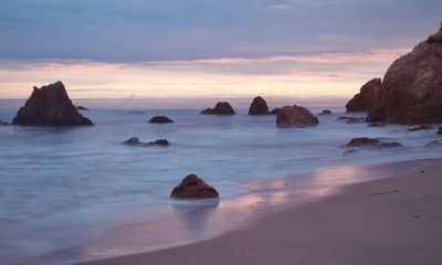 Fototapeta na wymiar rocks in sea against sky during sunset