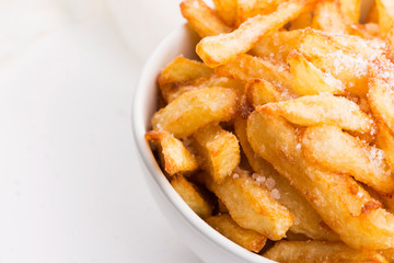 Bowl of potatoe fries on a white background