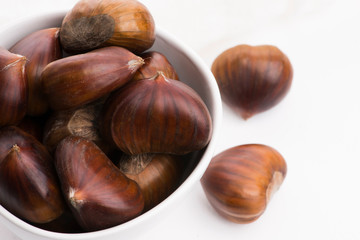 Bowl of chestnuts on a white background