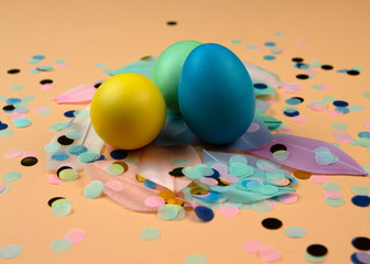 Easter composition of multicolored colorful easter eggs and feathers on pastel background. Happy Easter holidays.