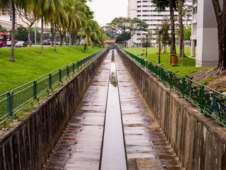 Tree lined water canal channel in a residential housing estate in Singapore
