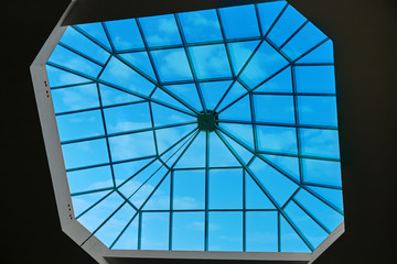 Sky through the glass window at the top of the building. Modern window in the roof of the building, designed for natural light and ventilation.
