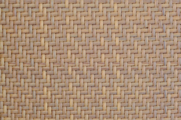 Symmetrical braided wooden texture brown color. Smooth texture of the woven fiber straw furniture. Brown background of woven bark.