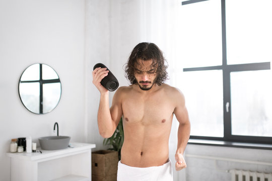 Energetic Guy With Portable Wireless Bluetooth Speaker Dancing In Bathroom