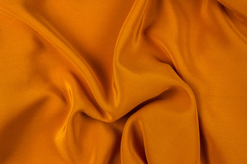 Golden silk or satin luxury fabric texture can use as abstract background.