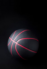 Black basketball on black background.