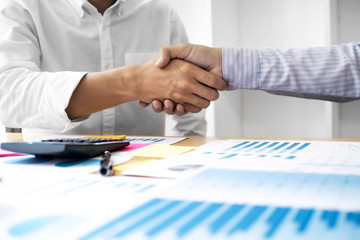 Business executives shaking hands after meeting at office, colleagues management