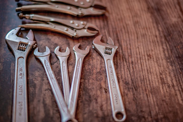 Selective focus on DIY wrench tools on a plain wooden background