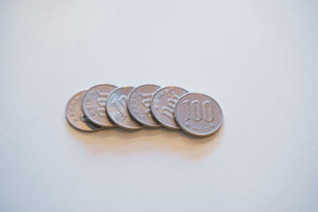 Japanese 100 yen coins on white background.