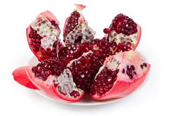 Pieces of splitted pomegranate fruit on the white dish