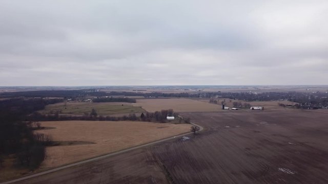 Aerial fly over view of harvested fields and timber woods in the fall