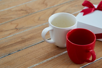 Two red and white mug coffee on wooden