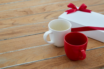 Two red and white mug coffee on wooden