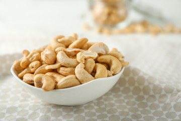 Bowl with tasty cashew nuts on table