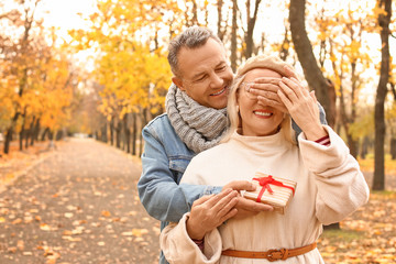 Naklejka premium Mature man greeting his wife in autumn park