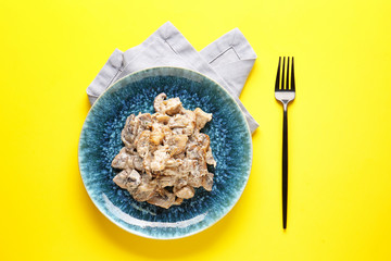 Plate with tasty cooked mushrooms on color background