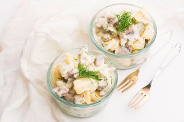 Salad rasols made of herring, cucumber and potato, dressed with mayonnaise and mustard