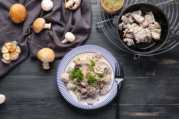 Tasty cooked mushrooms on dark table