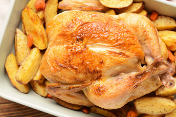 Dish with baked chicken and potato, closeup