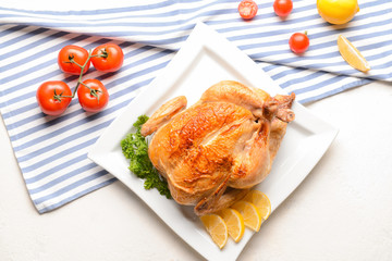 Plate with baked chicken on white background