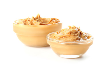 Tasty peanut butter in bowls on white background