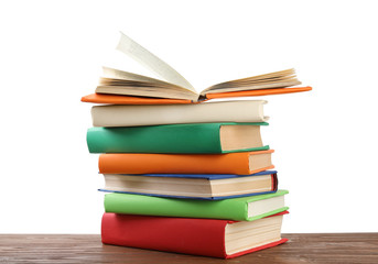 Stack of colorful books on wooden table against white background