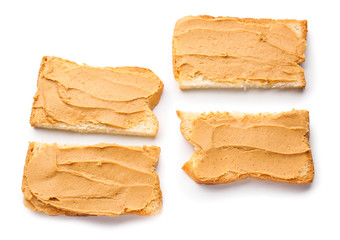 Slices of bread with tasty peanut butter on white background