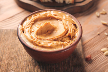 Bowl with tasty peanut butter on table
