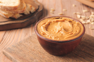 Bowl with tasty peanut butter on table