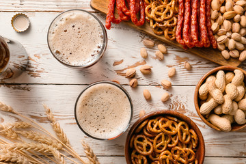 Composition with fresh beer and snacks on wooden background