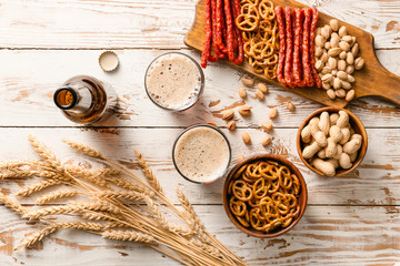 Composition with fresh beer and snacks on wooden background