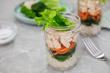 Healthy salad in glass jar on marble table