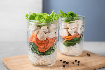 Fototapeta na wymiar Healthy salad in glass jars on light table