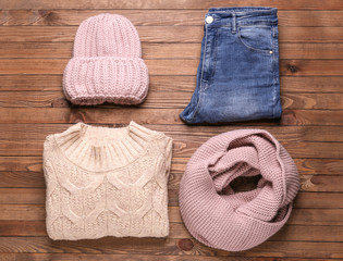 Set of winter clothes on wooden background