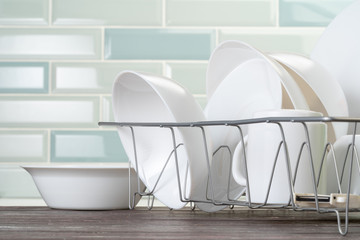 Dish rack with clean dry dishes on kitchen counter