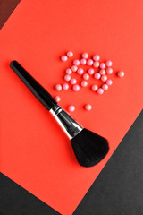Makeup brush and rouge balls on color background