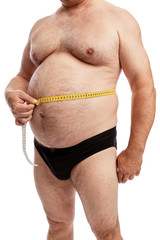A fat man in shorts measures the volume of the abdomen. Isolated over white background. Close-up....