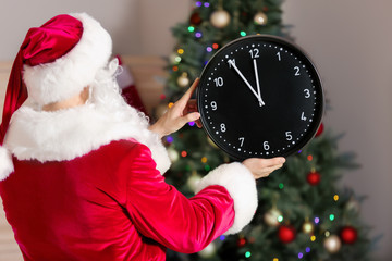 Santa Claus with clock in room. Christmas countdown concept