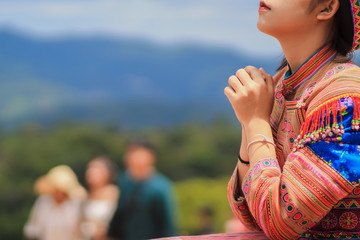 A young woman shows the symbol of prayer to God for the blessings of the Lord to find good things...
