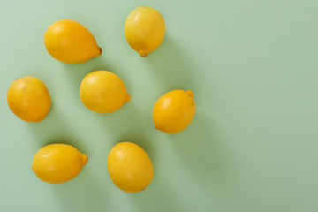 Fototapeta na wymiar Lemons isolated on green background. High Angle View Of Lemons. Free space for text.