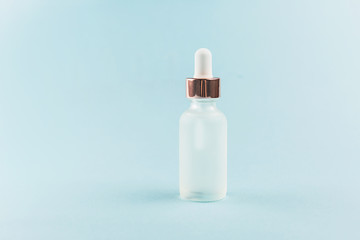 Serum bottle on palm leaf. Blue background.
