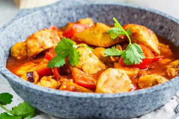 Jalfrezi chicken in fried pan with a bowl of rice, close up. Traditional indian cuisine concept.