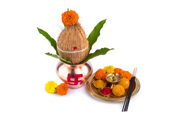 Copper Kalash with coconut and mango leaf and pooja thali with diya, kumkum and sweets with floral...
