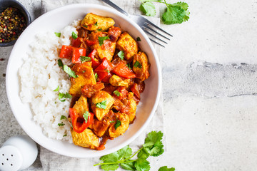 Jalfrezi chicken with rice in white bowl, top view, copy space. Traditional indian cuisine concept.
