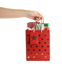 Woman holding shopping paper bag with presents on white background, closeup
