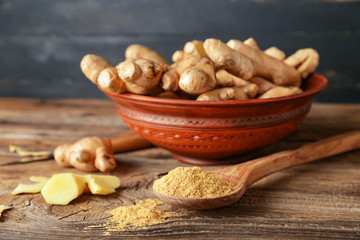 Fresh and ground ginger on wooden table